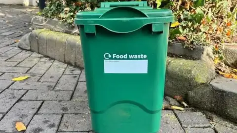 A green food waste collection bin