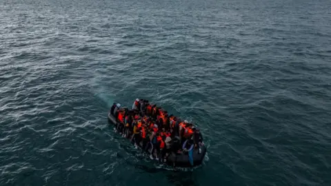 Reuters An image taken from a drone shows an inflatable dinghy packed full of migrants  wearing orange life vests making its way towards the UK in the English Channel