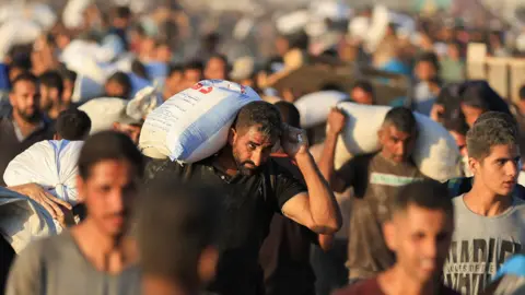 The Palestinians are carrying aid supplies in Beit Lahia in the northern Gaza Strip