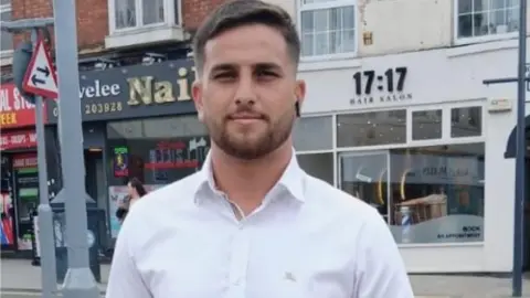 Ibrahim Yesildeniz. He is looking at the camera and wearing a white shirt. 