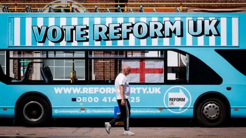 EPA A person walks past a Reform UK campaign bus outside Clacton station in Clacton-on-Sea, Essex, Britain, 04 August 2026. Reform UK leader Nigel Farage will contest the Clacton by-election on 13 August in an effort to regain his seat after announcing his resignation as an MP on 07 July 2026 following a row over his financial affairs. Major UK political parties are not contesting the election, while satirical candidate Count Binface is polling second with support from around 20 percent of Clacton voters, according to a recent Survation poll.
Clacton ahead of parliamentary by-election, Essex, United Kingdom - 04 Aug 2026