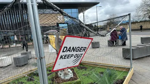 Local Democracy Reporting Service A damaged cage containing a dinosaur sculpture