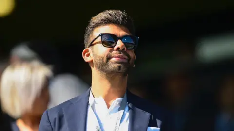 Amit Bhatia looks on from the Loftus Road directors' box during a Championship match