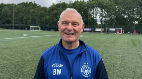 Halas Hawks FC club treasurer Brian Wilkes standing on the pitch.