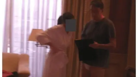 US Department of Justice A photograph of Lord Peter Mandelson in his underwear, standing next to a woman wearing a dressing gown whose face has been redacted.
