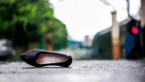 EPA The right side par of a black school shoe lays on the payment after the Tacloban high school mass shooting in the Philippines