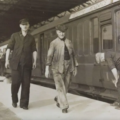 Dairy Herald Archive/Getty Images Black and white image of train workers next to the Aberdeen to Penzance train in 1939.
