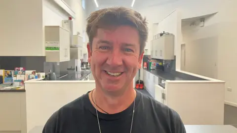 Craig Lloyd smiling at the camera standing in front of a kitchen at the Recreation Centre on the Hamp estate in Bridgwater