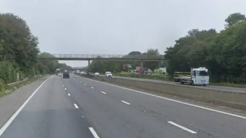 A shot of the M4 motorway. A bridge can be seen crossing over the carriageways. 