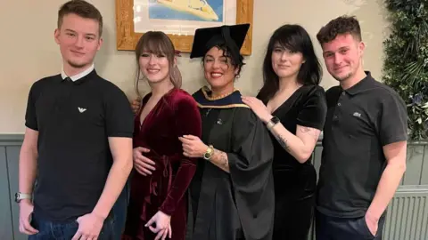 Stacey Barker Five people standing in a line. From left to right Ed O'Brien's brother, Stanley, his sister Alice, his mum, Stacey, his sister, Emily and Ed.
