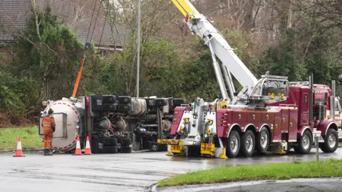 Eddie Mitchell Un camión es recogido por otro vehículo grande.