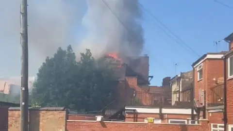 Damian Spencer Flames and smoke were seen coming out of the building's roof