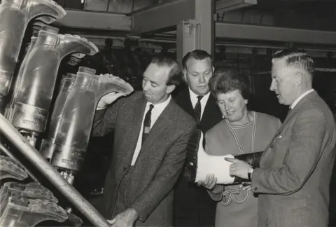 Heritage Service, Dumfries and Galloway Council Three men and a woman check out the wellington boots coming off a production line