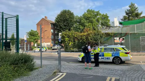 BBC/Anna O'Neill A police officer speaks to a person 