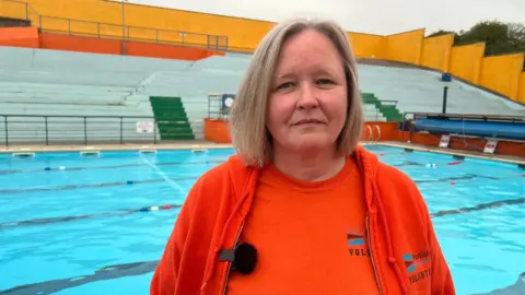 BBC Emma Pusill stands in front of a pool