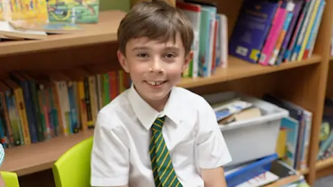 Child wearing school uniform and smiling