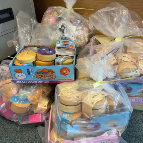 Hull City Council Four plastic bags full of seized toys, including purple squishy "dumplings", gold-coloured plastic "steamers" and boxes with colourful drawings and logos on them.