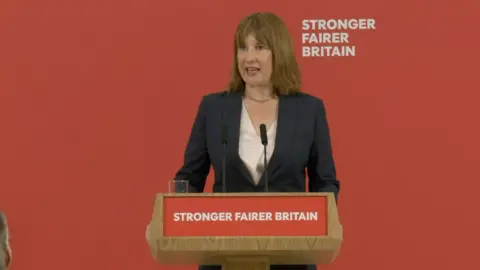 Rachel Reeves wearing white shirt and black blazer during speech