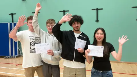 Tom Jackson /BBC Four students holding their certificates smiling for the camera 