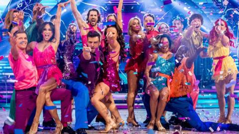 Strictly 2023 professionals and celebrities posing on the dancefloor with confetti falling