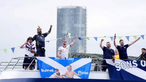 PA Media Scotland fans aboard a party boat on the Rhein River in Cologne