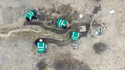 Anglian Water Four people excavating the ichthyosaur fossil