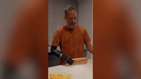 A man with a prosthetic arm holds a ciabatta 