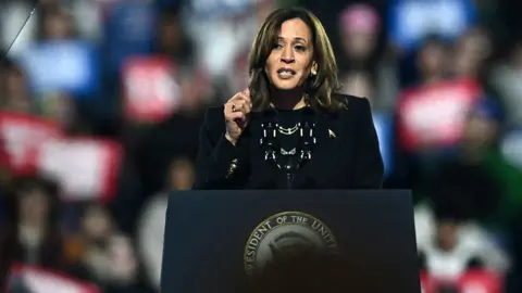 Kamala Harris looks to the left of camera while speaking at a lecturn at a campaign event