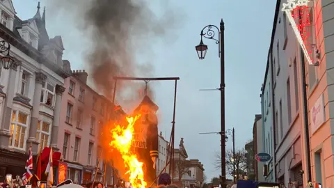 BBC An effigy of 'Lundy the Traitor' being burned in a crowded street.
