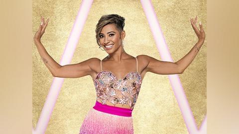 Karen Hauer in a dance costume smiling with her arms stretched out