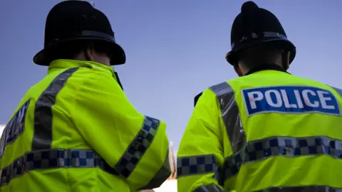 A generic picture of two police officers standing outside against a blue sky. 