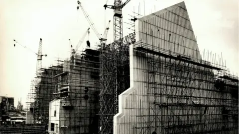 Carlsberg Tall concrete factory building under construction with scaffolding 