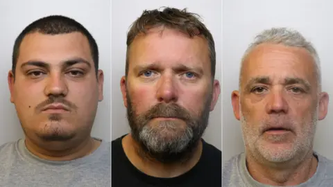 Police custody images of Anestis Tsepa, Raymond Nuttall and Craig Nuttall. Tsepa has close cropped dark hair, dark facial hair and wears a grey prison tracksuit. Raymond Nuttall has short brown hair, a brown beard and wears a black tee-shirt. Craig Nuttall has short grey hair, grey stubble and wears a grey prison tracksuit. 