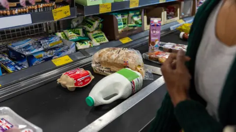 Getty Images Eggs, bread, milk, and other food on a conveyor belt