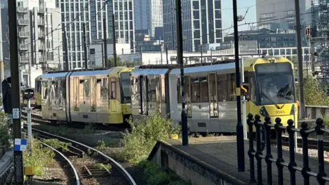 A Metrolink tram sightly off the tracks at Cornbrook stop in Greater Manchester