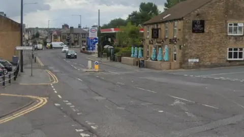 Road surface in need of repair at a crossroads in Lancashire.