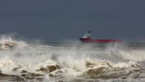 Getty Images A stock image of a ship in stormy seas off Aberdeen, Scotland.