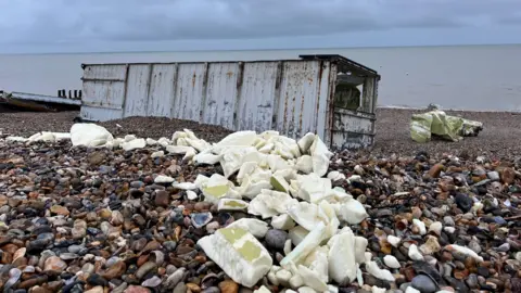 Debris from the containers strewn across the pebble beach in Selsey. It all appears to be packaged up.