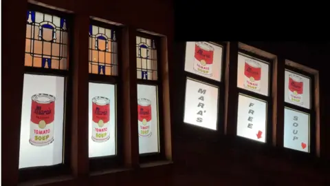 Mara's window display features images of tomato soup tins 