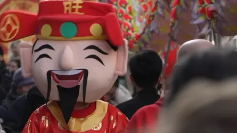 Person wearing Chinese New Year costume in parade in Leicester city centre