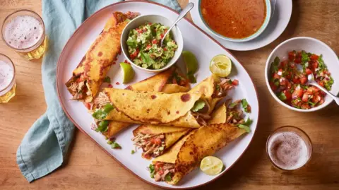 A plate of turkey birria tacos with guacamole and salsa