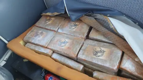 NCA Packages of cocaine, which look like bricks, wrapped and stashed inside a seat onboard the plane.