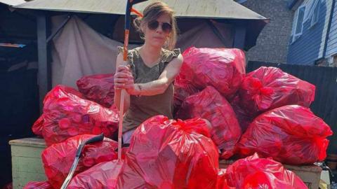 Volunteer with bags of litter 