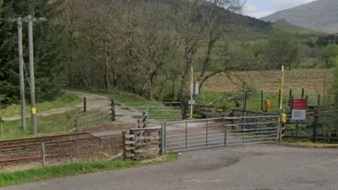 Google A railway crossing with metal gates on each side