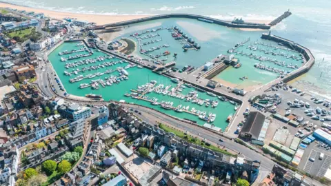 Aerial view showing Ramsgate Royal Harbour, marina, and beach on a sunny day 