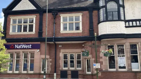 LDRS A two-storey high street building with a blue NatWest sign above the first floor windows on the left.