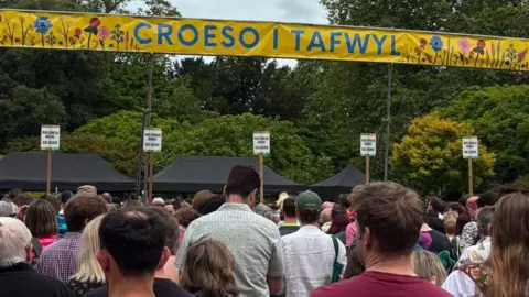 The backs of a large number of people queuing to gain entry to the Tafwyl festival in Cardiff on Saturday