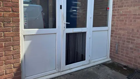 A white PVC door with a panel missing at the bottom.