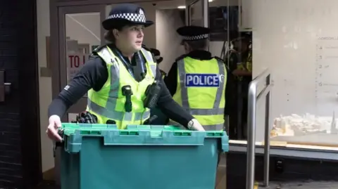 PA Media Police bring out boxes from SNP HQ