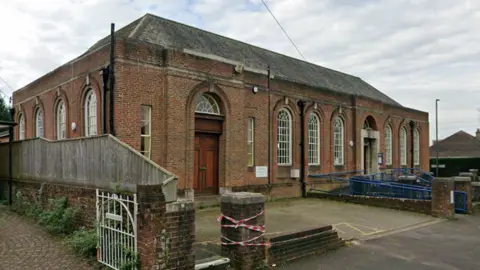Google Streetview image of a red brick building, which is Charminster Library